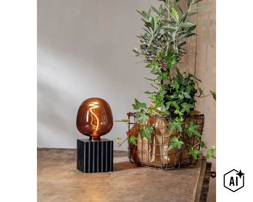 Tafellamp met glazen lichtbron op een geribbelde voet naast een groene plant in een draadmand op een rustieke houten tafel. (Image AI modified or generated)