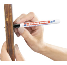 Een hand gebruikt een Edding 8850 boorgatmarker om te markeren op een houten lat.