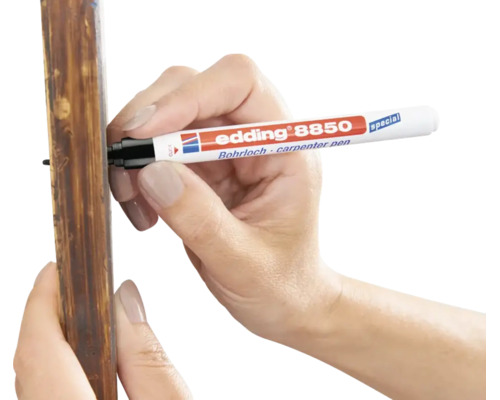 Een hand gebruikt een Edding 8850 boorgatmarker om te markeren op een houten lat.
