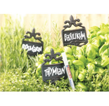 Drie rustieke metalen plantenlabels met opschrift tussen verse kruiden en een Edding marker voor gladde oppervlakken.