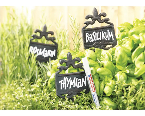 Drie rustieke metalen plantenlabels met opschrift tussen verse kruiden en een Edding marker voor gladde oppervlakken.