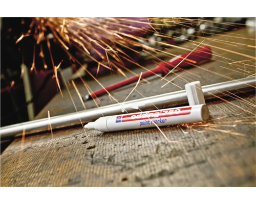 Edding 750 lakmarker op een houten werkbank met metalen staaf en vonken op de achtergrond.