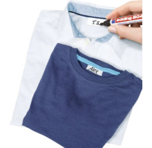 Een Edding 804 wasgoedmarker wordt gebruikt om een label in een overhemd te beschrijven, met een reeds beschreven T-shirt op de voorgrond.