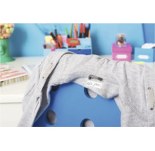 Een gepersonaliseerd naamlabel voor kleding geplakt op een grijze hoodie die over de rugleuning van een blauwe stoel in een kinderkamer hangt.