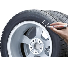 Een hand markeert een autoband met een Edding 8050 bandenmarker.