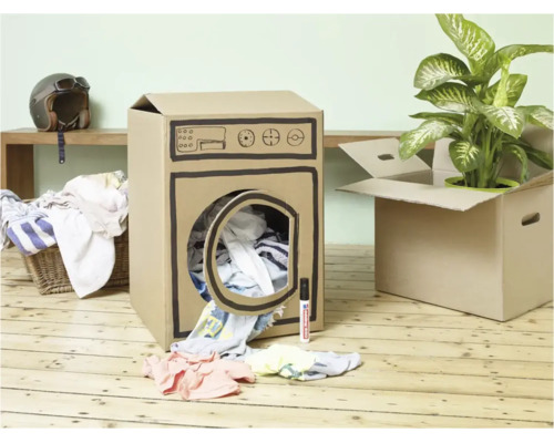 Een wasmachine geknutseld uit een kartonnen doos op een houten vloer met kleding en een Edding stift ernaast.