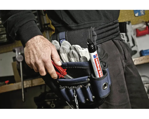 Vakman met een gereedschapsriem voorzien van werkhandschoenen en een Edding permanente marker in een werkplaatsomgeving.