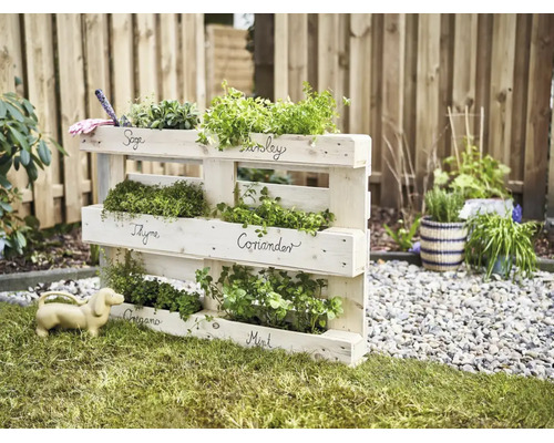 Houten pallet kruidenrek voor de tuin met gelabelde vakken voor diverse kruiden.