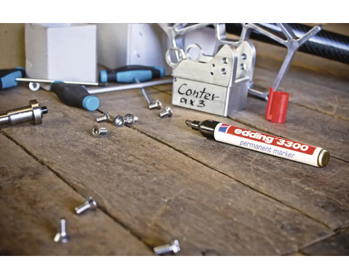Edding 3300 permanente marker op een werkbank met metalen onderdelen en schroeven.