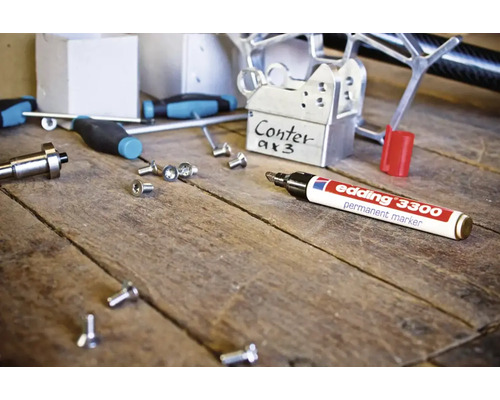 Edding 3300 permanente marker op een werkbank met diverse gereedschappen en metalen onderdelen