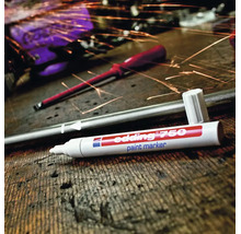 Edding 750 lakmarker op een werkbank met metaalsnippers
