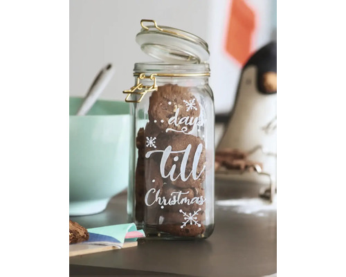 Een glazen voorraadpot met beugelsluiting, gevuld met koekjes en voorzien van de tekst days till Christmas en sneeuwvlokken.