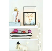 Kerstdecoratie op een plank met een lantaarn met tekst make a wish, kerstballen in een mand en kerstverlichting op witte planken.