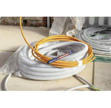 Een gele elektriciteitskabel ligt op een rol flexibele buis samen met een Edding 8407 speciale stift voor kabelmarkering.