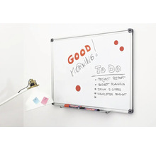 Een whiteboard met aluminium frame aan een muur, beschreven met tekst en taken, inclusief pennenbakje en stiften.