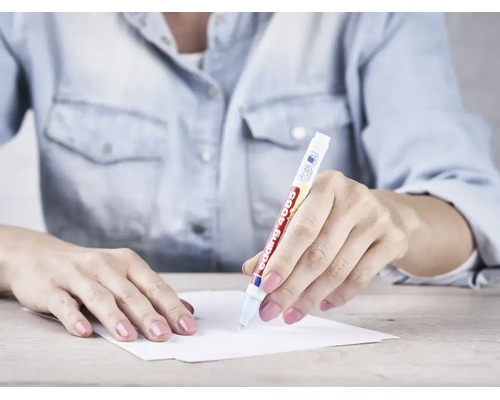 Een persoon schrijft op een vel papier met een Edding 4085 krijtmarker.