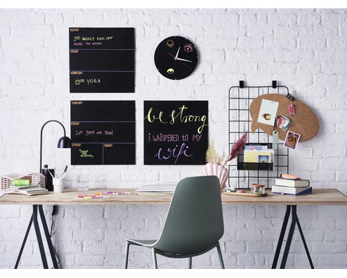 Modern thuiskantoor met wandborden, prikbord, wandklok en een bureau voor een witte bakstenen muur.