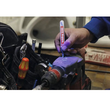 Hand markeert een boorhamer met een Edding 8280 veiligheidsmarker die ultraviolette inkt gebruikt voor diefstalbeveiliging