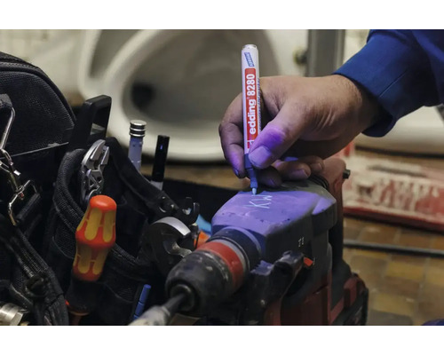 Hand markeert een boorhamer met een Edding 8280 veiligheidsmarker die ultraviolette inkt gebruikt voor diefstalbeveiliging