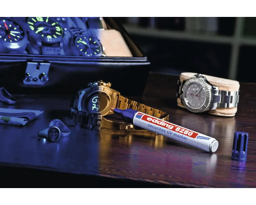 Edding 8280 Securitas UV-marker op een houten tafel met horloges en sieraden