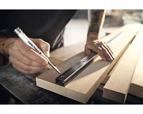 Vakman markeert boorgaten met een Edding 8880 diepgatmarker door een metalen profiel op een houten plank.