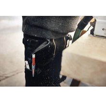 Een Edding diepgatmarker in een werkbroek tijdens houtbewerking in de werkplaats.