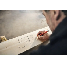 Vakman markeert getallen op een houten plank met een Edding 8850 diepgatmarker.