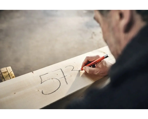 Vakman markeert getallen op een houten plank met een Edding 8850 diepgatmarker.