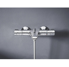 Wandgemonteerde thermostaatkraan voor de douche van metaal met waterdruppels op het oppervlak