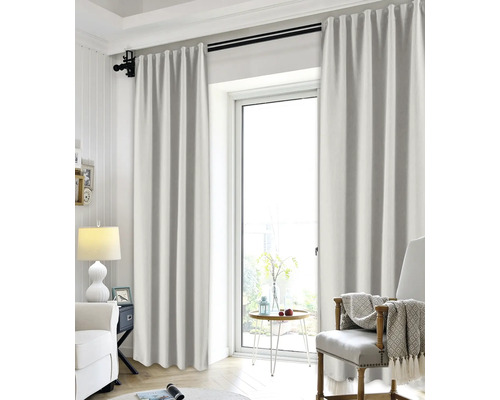 Lichte gordijnen aan een zwarte gordijnroede in een moderne woonkamer met kamerhoog raam en een gezellige inrichting.