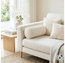 Een lichte bank met een ribfluwelen nekkussen, sierkussens en een sprei in een modern ingerichte woonkamer met bijzettafel en bloemenvaas. (Image AI modified or generated)