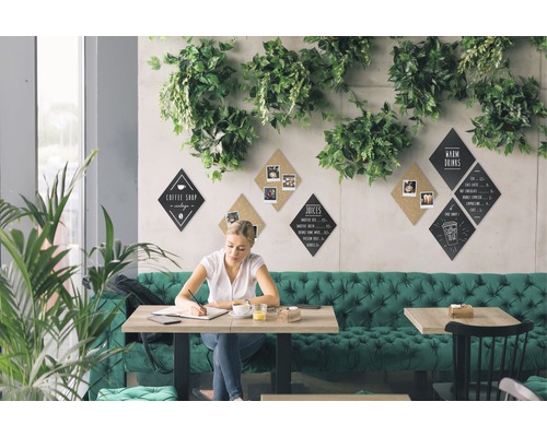 Vrouw zit aan een tafel in een café met menuborden aan de muur.