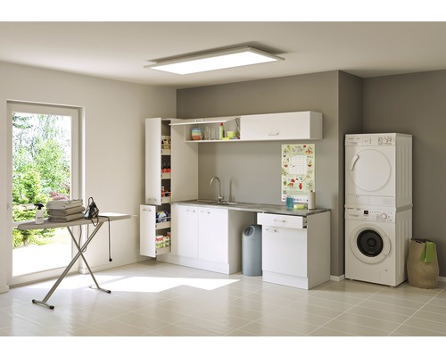 Lichte wasruimte met wasmachine, droger, wastafel, kasten en strijkplank