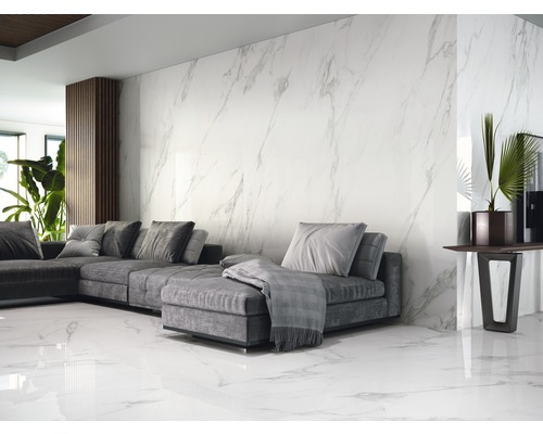 Woonkamer met grijze bank, decoratie en wand- en vloertegels in marmerlook