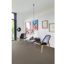 Woonkamer met tapijt, twee stoelen, een tafel en kunst aan de muur