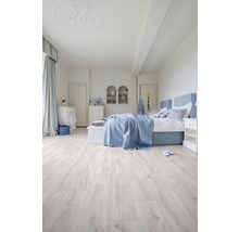 Lichte slaapkamerruimte met bed en houten vloer
