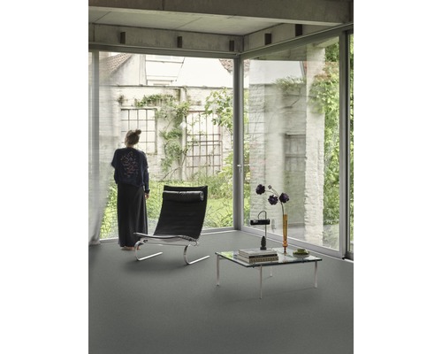 Lichte kamer met groot raam, fauteuil en salontafel op een vloer