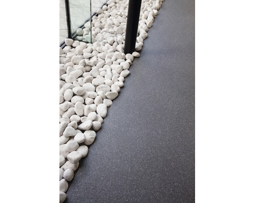 Decoratieve witte kiezelstenen naast grijze vloerbedekking