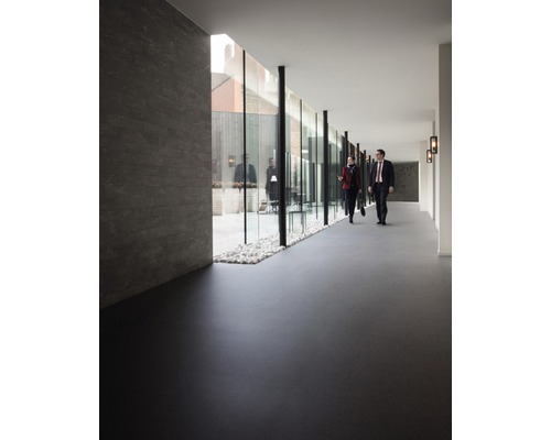 Interieur met donkere vloer en glazen wand naar een buitenruimte met grind