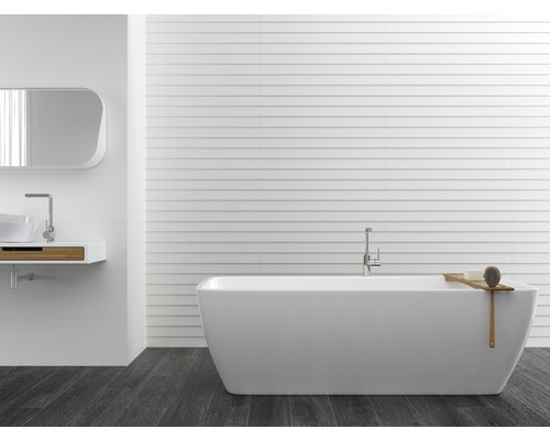 Badkamer met bad, wastafel en spiegel