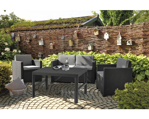 Tuinmeubelset met tafel, stoelen en bank op een terras