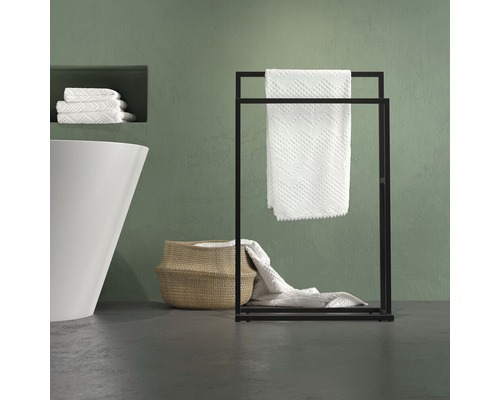 Vrijstaande metalen handdoekhouder met handdoeken in de badkamer.