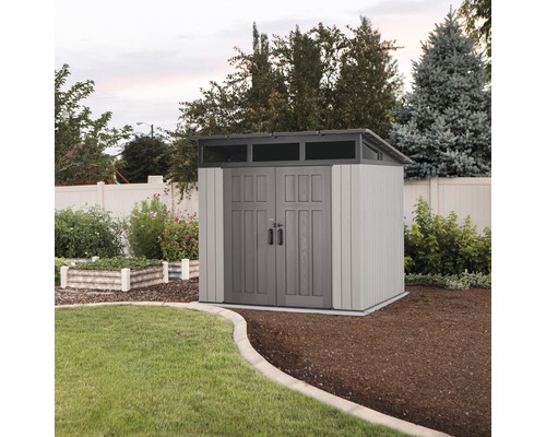 Tuinhuis met dubbele deur en bovenlicht in een verzorgde tuin.