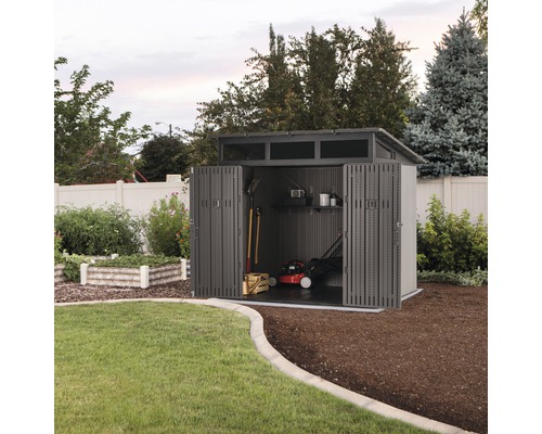 Tuinhuis met open deuren, grasmaaier en tuingereedschap erin.