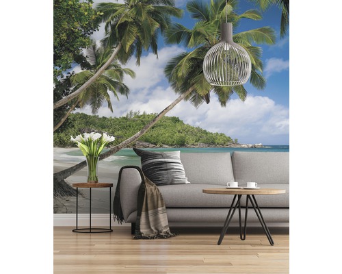 Woonkamer met fotobehang met een tropisch strand met palmbomen en een blauwe lucht