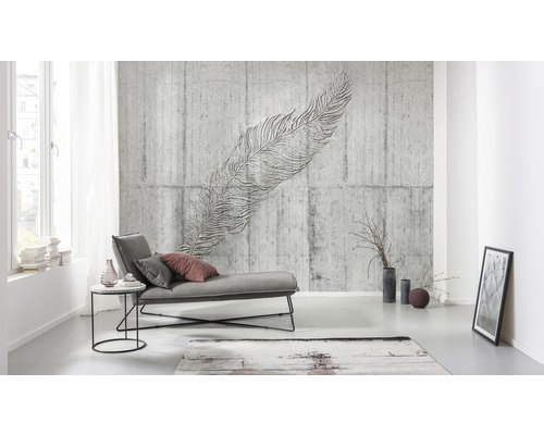 Woonkamer met grijze betonnen muur en veer muurschildering, ligstoel en decoratie