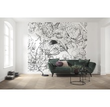 Woonkamer met bloemenbehang, groene bank en vloerlamp