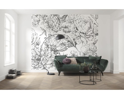 Woonkamer met bloemenbehang, groene bank en vloerlamp