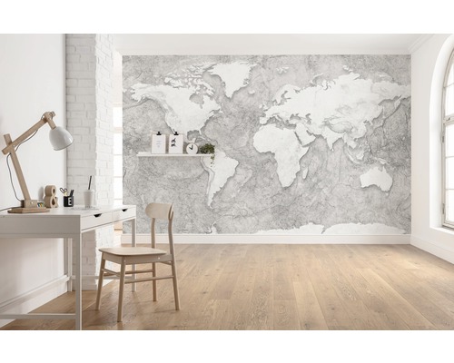 Lichte werkkamer met wereldkaartbehang, bureau en houten vloer.