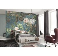 Slaapkamer met bloemenbehang, bed, tapijt en fauteuil